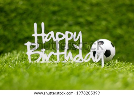 Happy Birthday sign with soccer ball on green grass