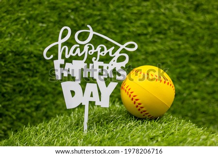 Happy Father ' s day with softball are on green grass
