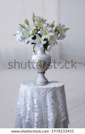 Still life with a bouquet of white lilies in an antique vase