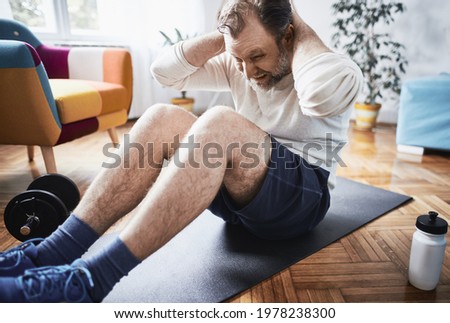 Man working out at home. Home workout in living room. Man exercising at home.