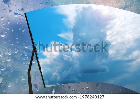 Car windshield wiper cleaning water drops from glass Royalty-Free Stock Photo #1978240127