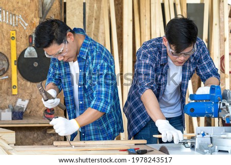 Carpenter using planning machine at carpentry shop. Wood processing apprenticeship at carpentry shop. Royalty-Free Stock Photo #1978243517