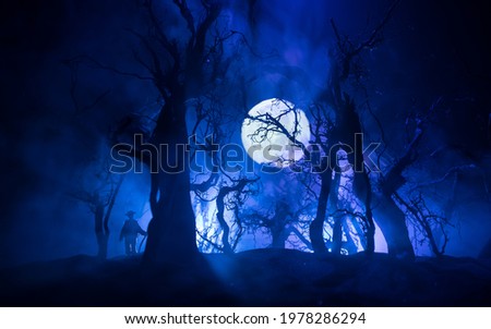 Silhouette of person standing in the dark forest. Horror halloween concept. strange silhouette in a dark spooky forest at night