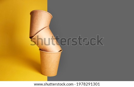 Eco natural paper cups on yellow gray background. Sustainable lifestyle concept. zero waste, plastic free, stop plastic pollution.