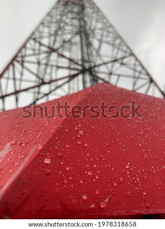 Red umbrella with water dots under the tower.