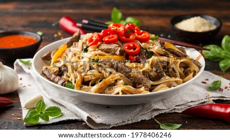 Stir fry Beef Chow Fun with rice noodles, bean sprouts, spring onions and chili. Royalty-Free Stock Photo #1978406246