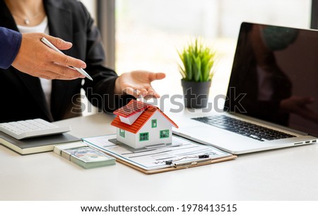 Close up house model with business man signs a purchase contract or mortgage for a home, Real estate concept.	