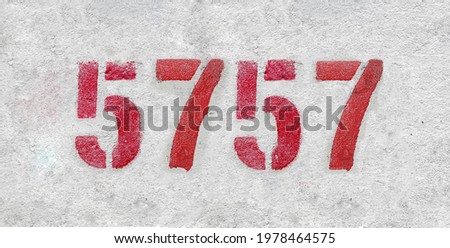 Red Number 5757 on the white wall. Spray paint.