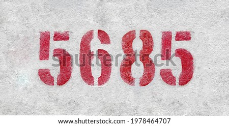 Red Number 5685 on the white wall. Spray paint.