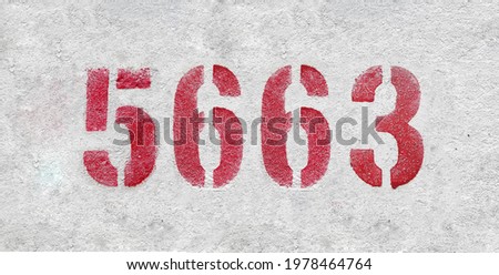 Red Number 5663 on the white wall. Spray paint.