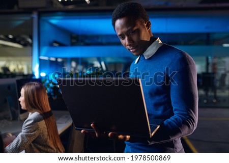 One manager works on laptop in night office