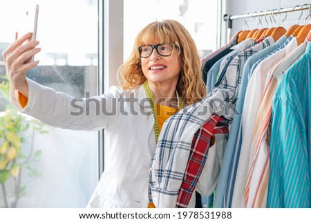 woman in fashion store taking picture with phone