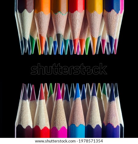 multicolored pencils opposite on a black background