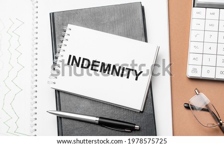 indemnity on notepad and various business papers on brown background. Brown glasses and magnifier with notepad. Royalty-Free Stock Photo #1978575725