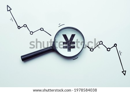 The concept of researching the dynamics of the growth and fall of the Yen currency in a glass magnifier. Royalty-Free Stock Photo #1978584038