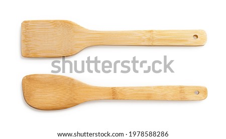 Two wooden spatulas for cooking isolated on white background. Simple rustic kitchenware of eco-friendly materials. New bamboo kitchen utensils for zero waste and green living lifestyle. Top view. Royalty-Free Stock Photo #1978588286