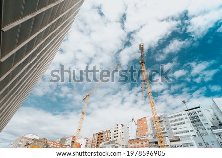 Bunch of yellow cranes on the city under a bright and blue sky with copy space