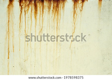Dark orange streaks on a pale yellow plaster wall Royalty-Free Stock Photo #1978598375
