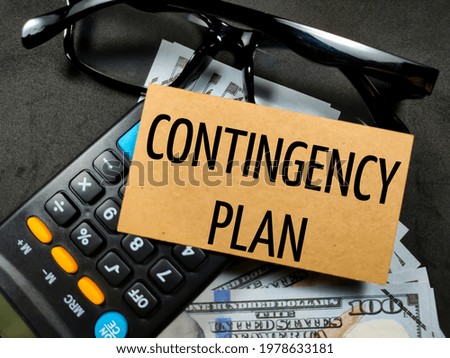 Business concept.Text CONTINGENCY PLAN with banknote,calculator and glasses on black background. Royalty-Free Stock Photo #1978633181
