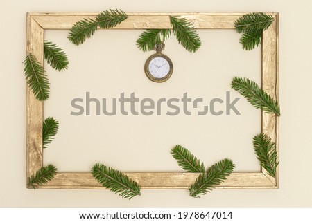Old wooden frame with green fir tree branches and vintage pocket watch show 10 oclock. Christmas eve and Happy New Year holiday background with copy space