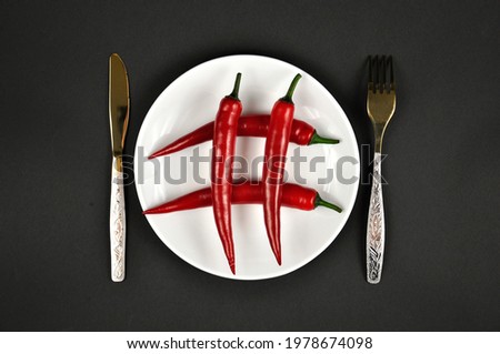 Hashtag. Red Chili peppers on a white plate.
