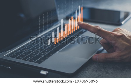 Laptop or computer with chart. Investment in business and financial concept of growth and success. Investor data analysis for planning in strategy of stock market fund. Invest for earning or profit. Royalty-Free Stock Photo #1978695896