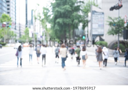 Blurred crowd of anonymous people, commuters walking on pedestrian and crossing the street in the city, Seoul, Korea