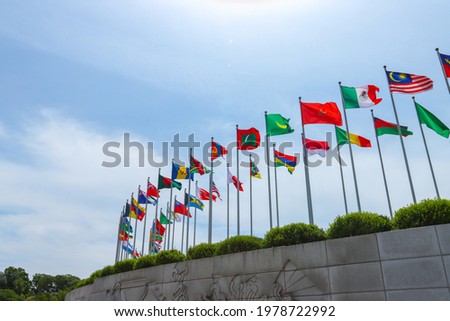 The blue sky and the various flags of the world fluttering in the wind.