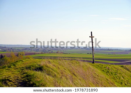 Rural landscape of meadows and fields and cross
