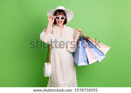 Photo portrait of girl amazed in sunglass keeping bags in shopping center isolated on pastel green color background