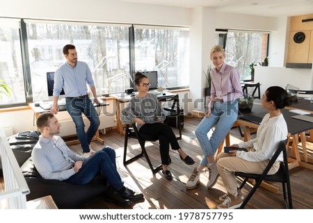 Diverse colleagues involved in briefing, sitting in circle, discussing project strategy or sharing ideas, successful employees coworkers listening to mentor coach at meeting, teamwork concept Royalty-Free Stock Photo #1978757795