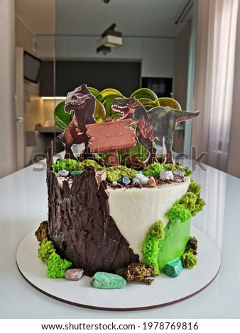 Two stylized dinosaur figures decorate a sweet cake