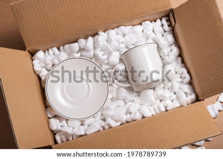 Fragile porcelain in loose white Filler Shipping Packing Peanuts Royalty-Free Stock Photo #1978789739