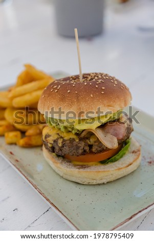 Delicious Gourmet Bacon and Avocado Burger with Rustic chips