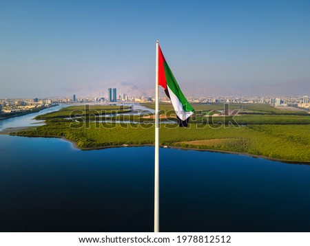 UAE national flag pole and Ras al Khaimah emirate in the northern United Arab Emirates aerial skyline landmark and skyline view above the mangroves and corniche downtown area Royalty-Free Stock Photo #1978812512