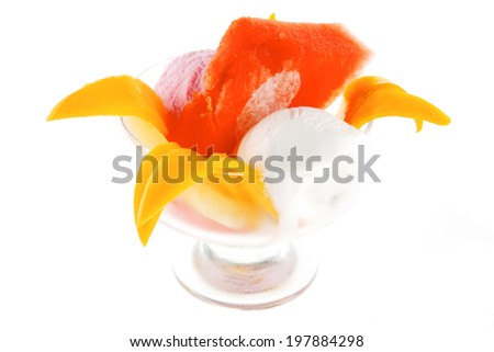 small transparent glass cup with ice cream and tropical fruits isolated on white background