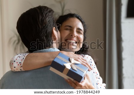 Cheerful sincere millennial hispanic woman cuddling husband, feeling thankful for prepare surprise gift, accepting happy birthday greetings or celebrating special family event anniversary, head shot. Royalty-Free Stock Photo #1978844249
