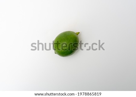 A green lemon on a white background