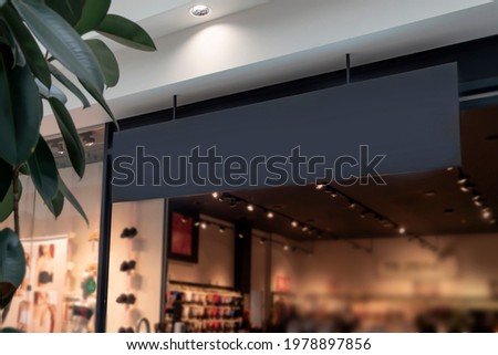 a black mockup sign over the entrance to the premium clothing store. Copy space for your text, logo, or ad.