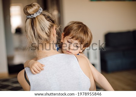Cold boy of 3 years old in arms of his mother. Children's distress at home. Royalty-Free Stock Photo #1978955846