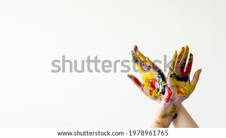 Color life. Art school banner. Inspiration freedom. Creative hobby. Advertising background. Crossing female hands in colorful paints splashes isolated white copy space wide ledge.