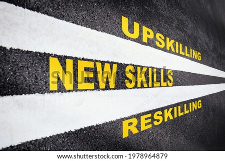 Self development concept and changing skill demand idea. New skills, reskilling and upskilling written on asphalt road with white marking line Royalty-Free Stock Photo #1978964879