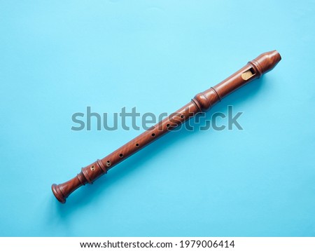 Baroque recorder isolated on blue background, musical education concept Royalty-Free Stock Photo #1979006414