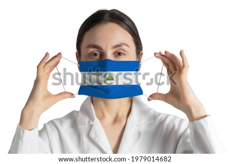 Respirator with flag of Nicaragua Doctor puts on medical face mask isolated on white background.