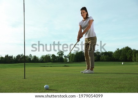 Beautiful woman playing golf on green course