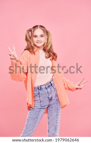 Teenage style. Pretty teenage girl in bright summer clothes and with funny ponytails smiling at camera. 