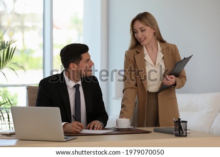 Secretary bringing coffee to her boss in office