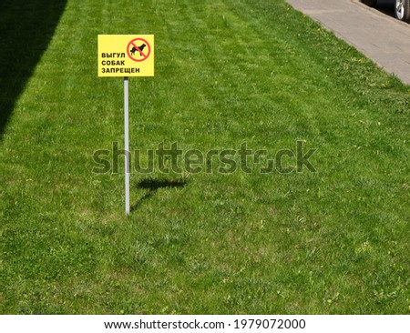dog walking is prohibitet sign written in russian language on the green grass