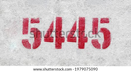 Red Number 5445 on the white wall. Spray paint.