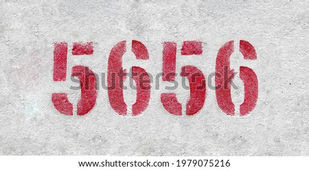 Red Number 5656 on the white wall. Spray paint.
